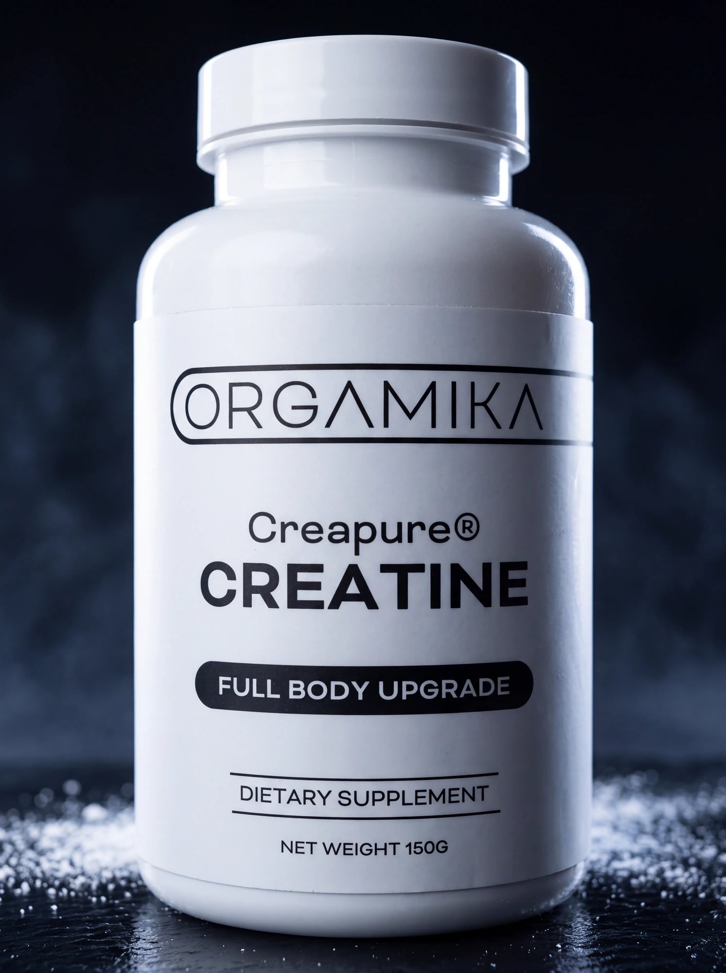 The white ORGAMIKA Creapure® Creatine 150g bottle lit against a dark misty backdrop, standing on a wet black surface scattered with loose creatine powder