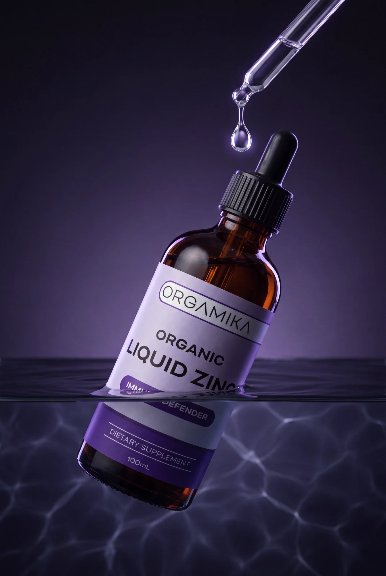 ORGAMIKA Liquid Zinc bottle over dark water, a droplet suspended above it