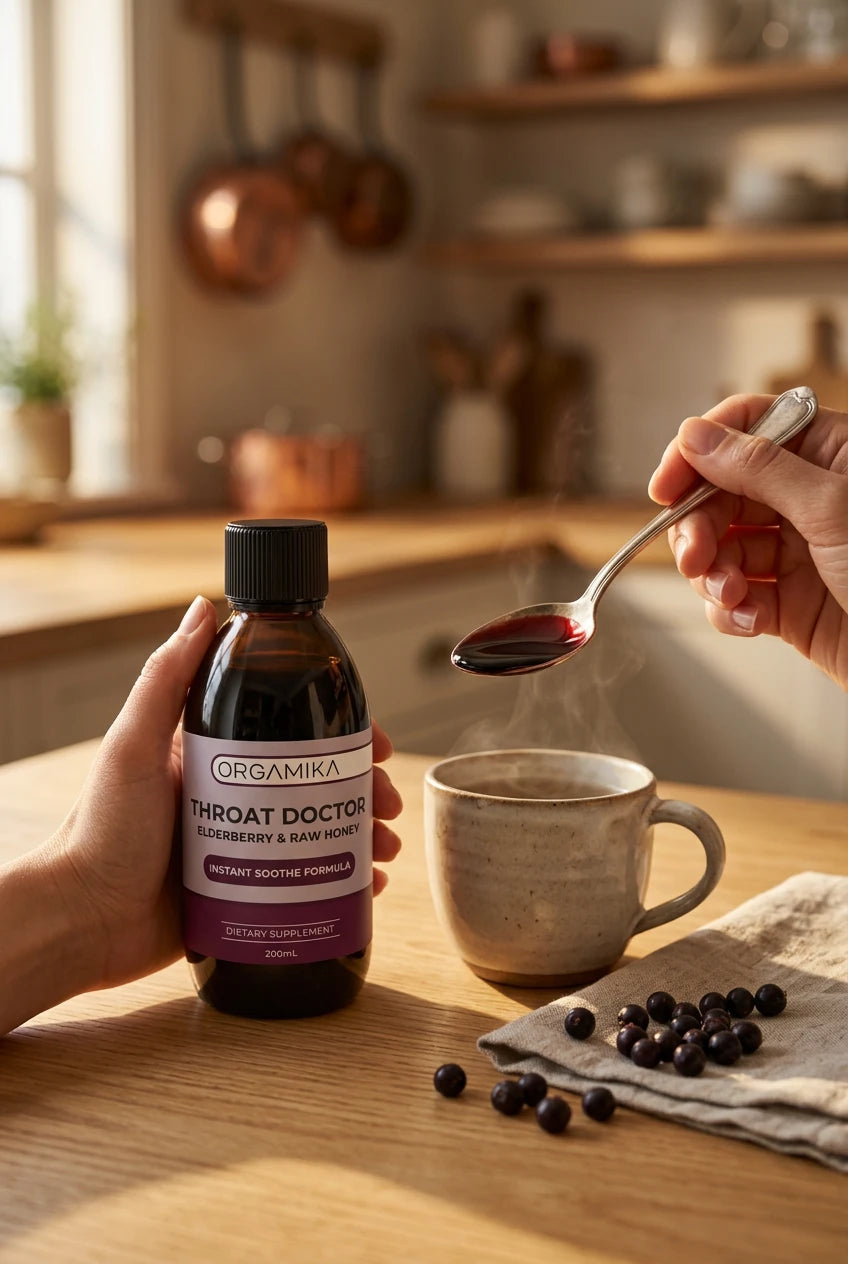 ORGAMIKA Throat Doctor bottle on wet slate with elderberries, elderflower and a honey dipper